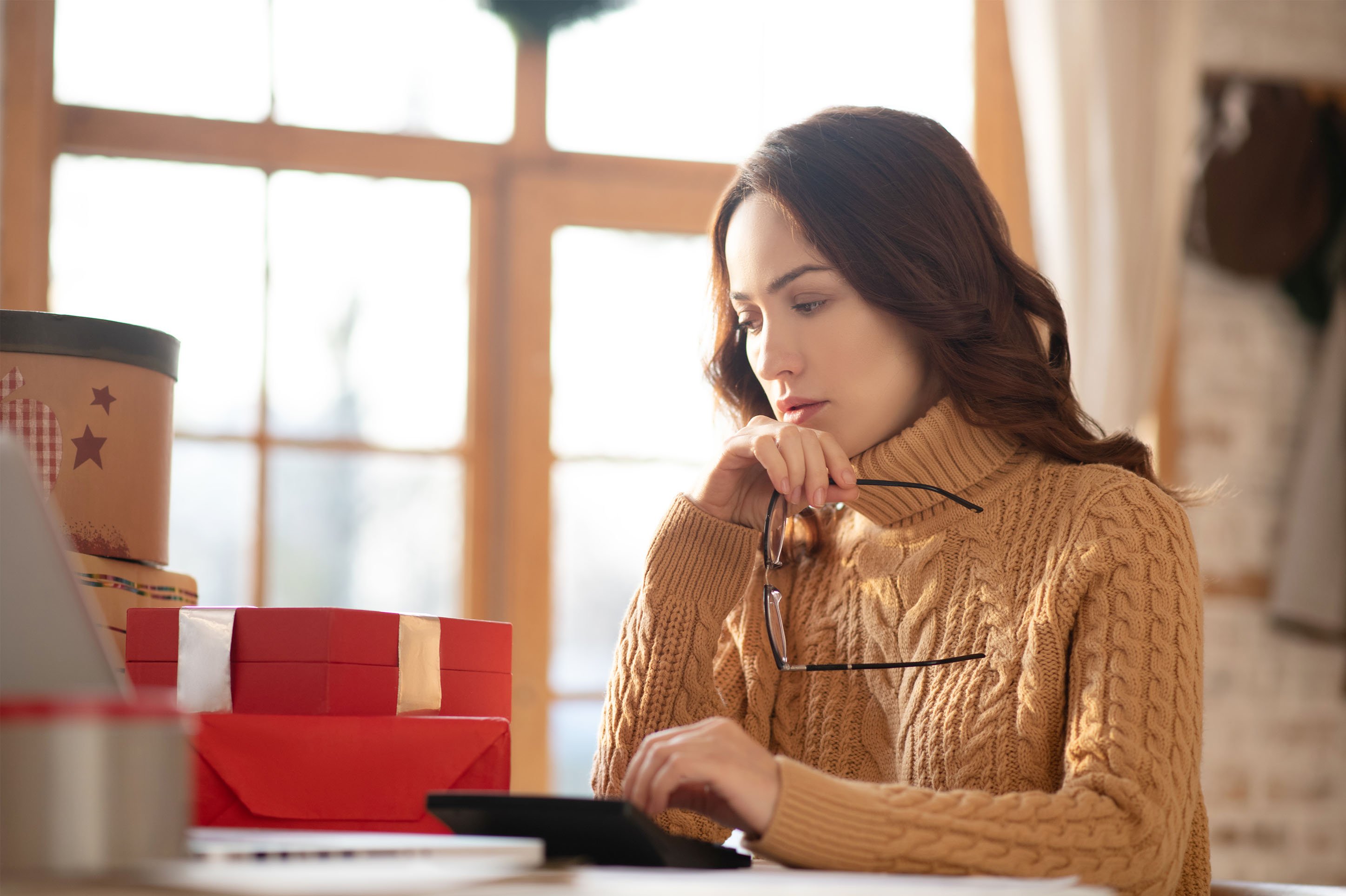 Woman in front of computer, anaylzing budget. 