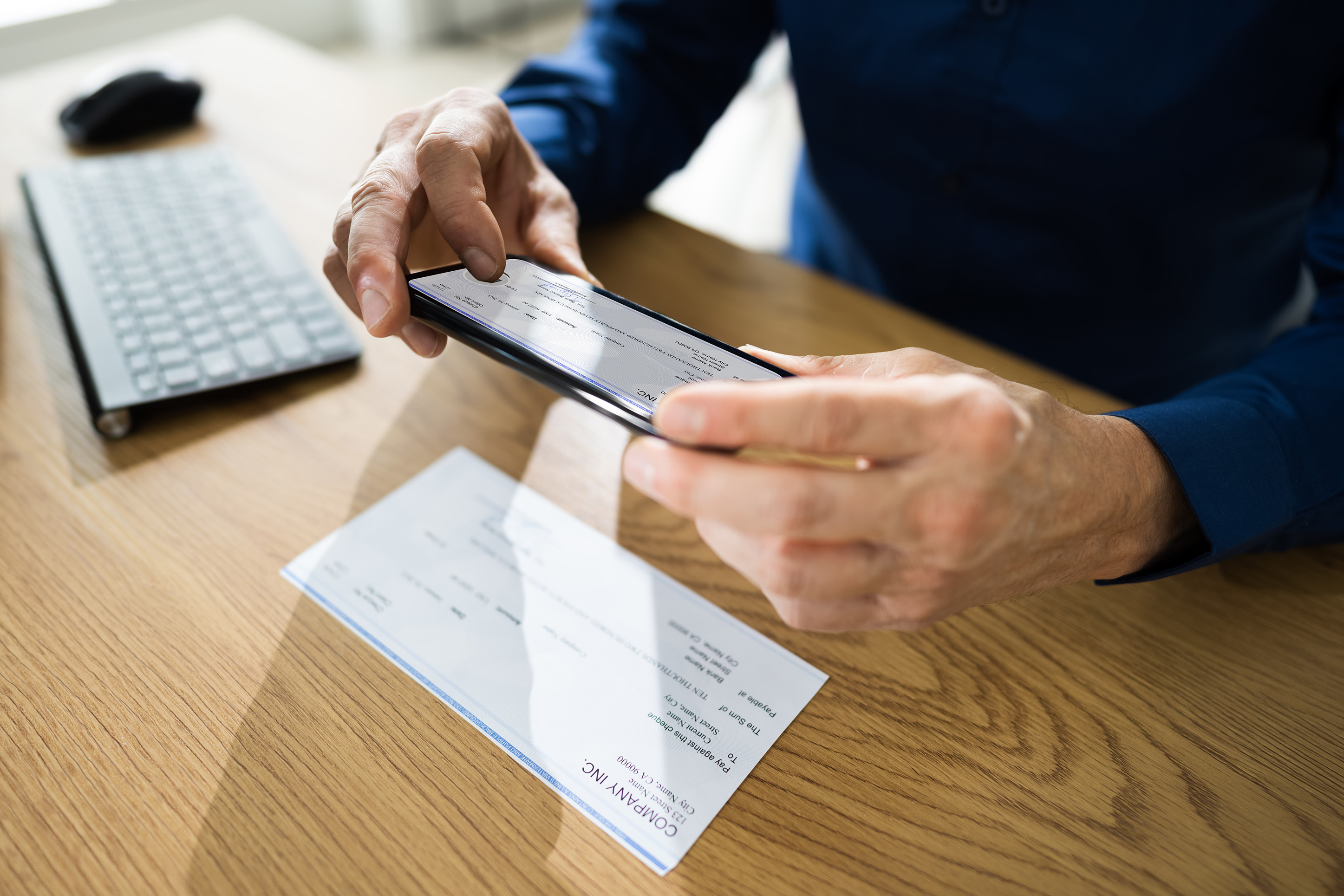 Person taking a photo of a check for mobile deposit. 
