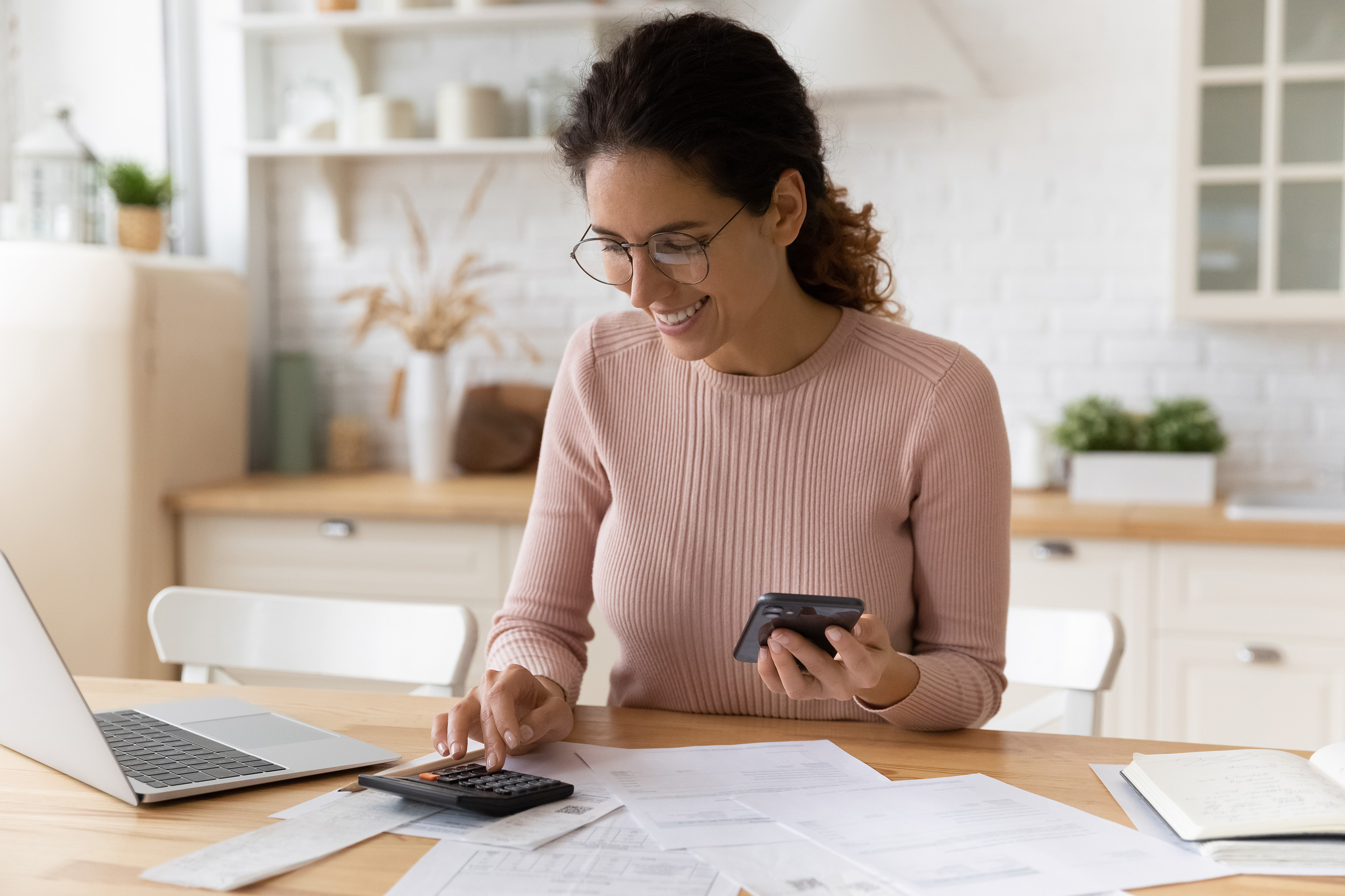Woman with a calculator budgeting.