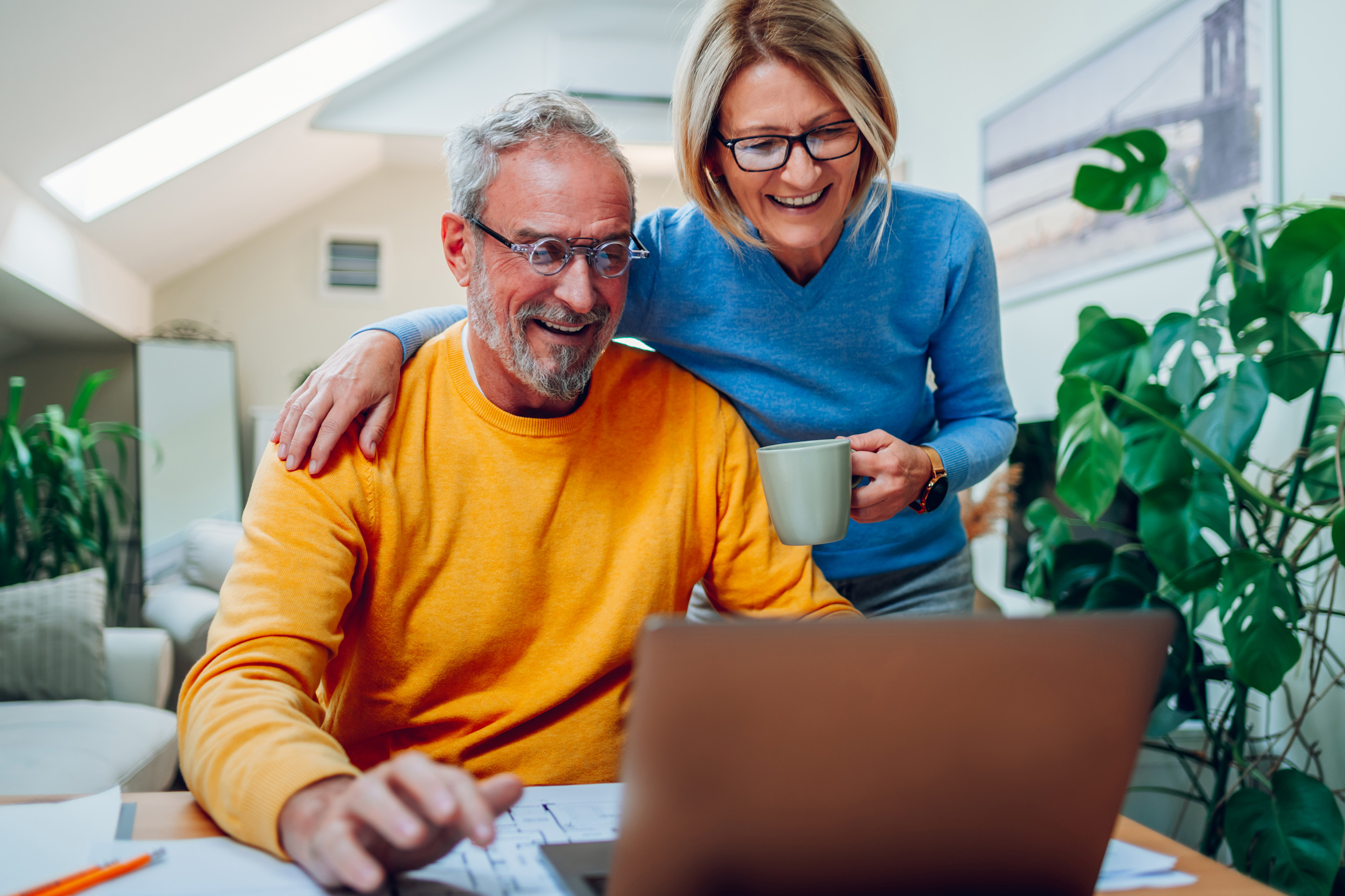 Man and woman looking at investments on a computer