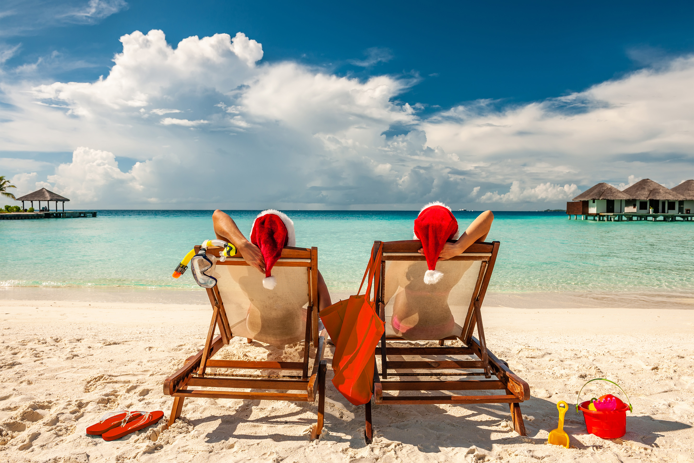Couple on a warm weather holiday wearing Santa hats. 