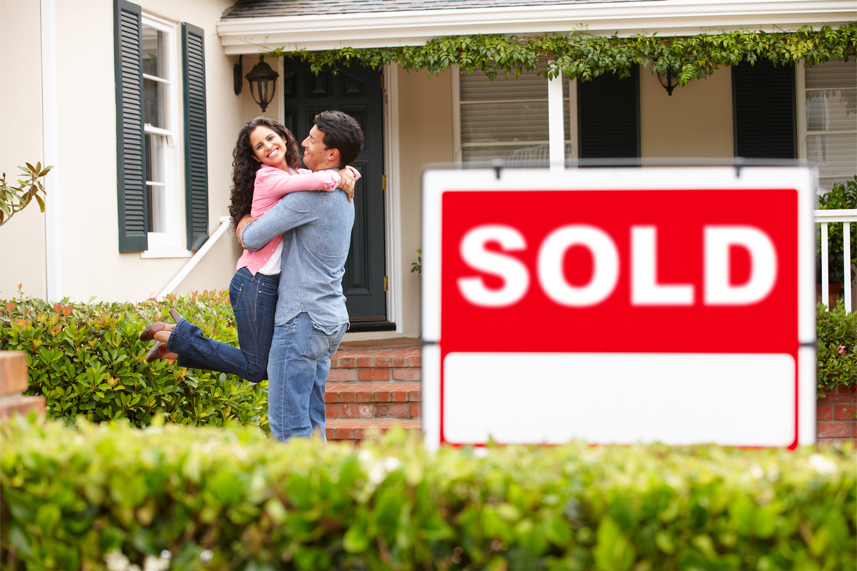 A couple hugging after purchasing a new home