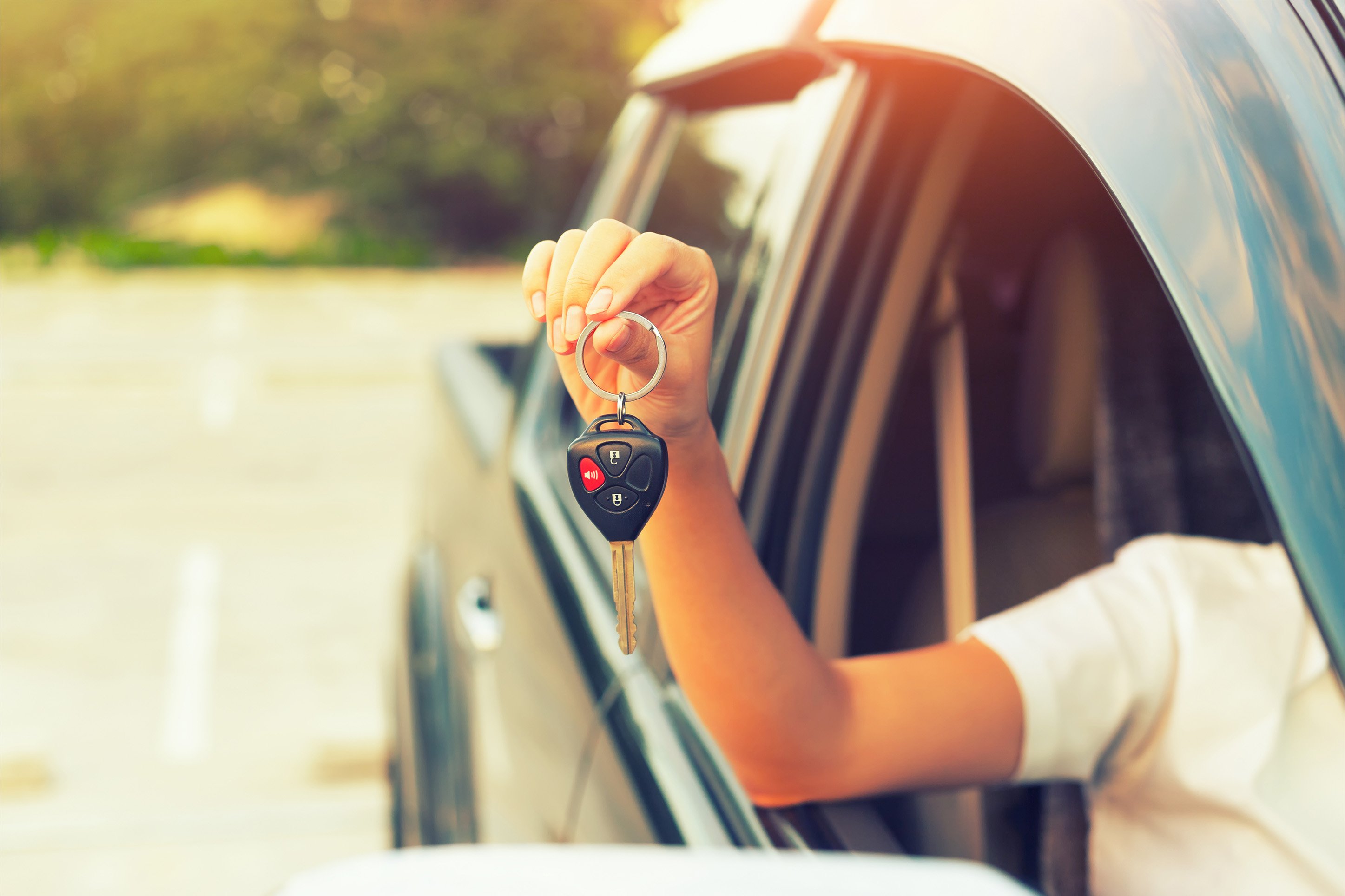 Person holding keys to a new car.
