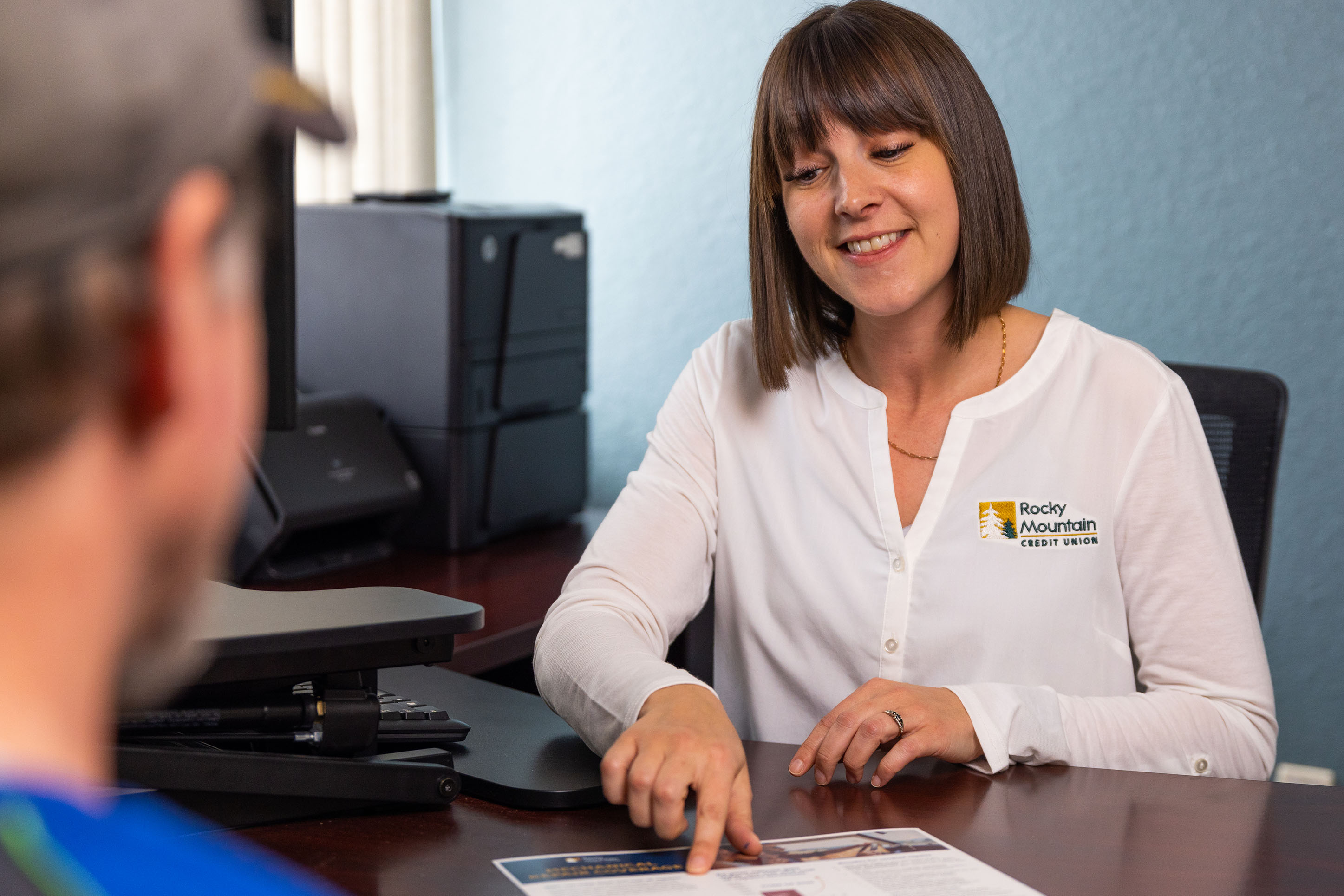 Employee of Rocky Mountain Credit Union helping a customer.
