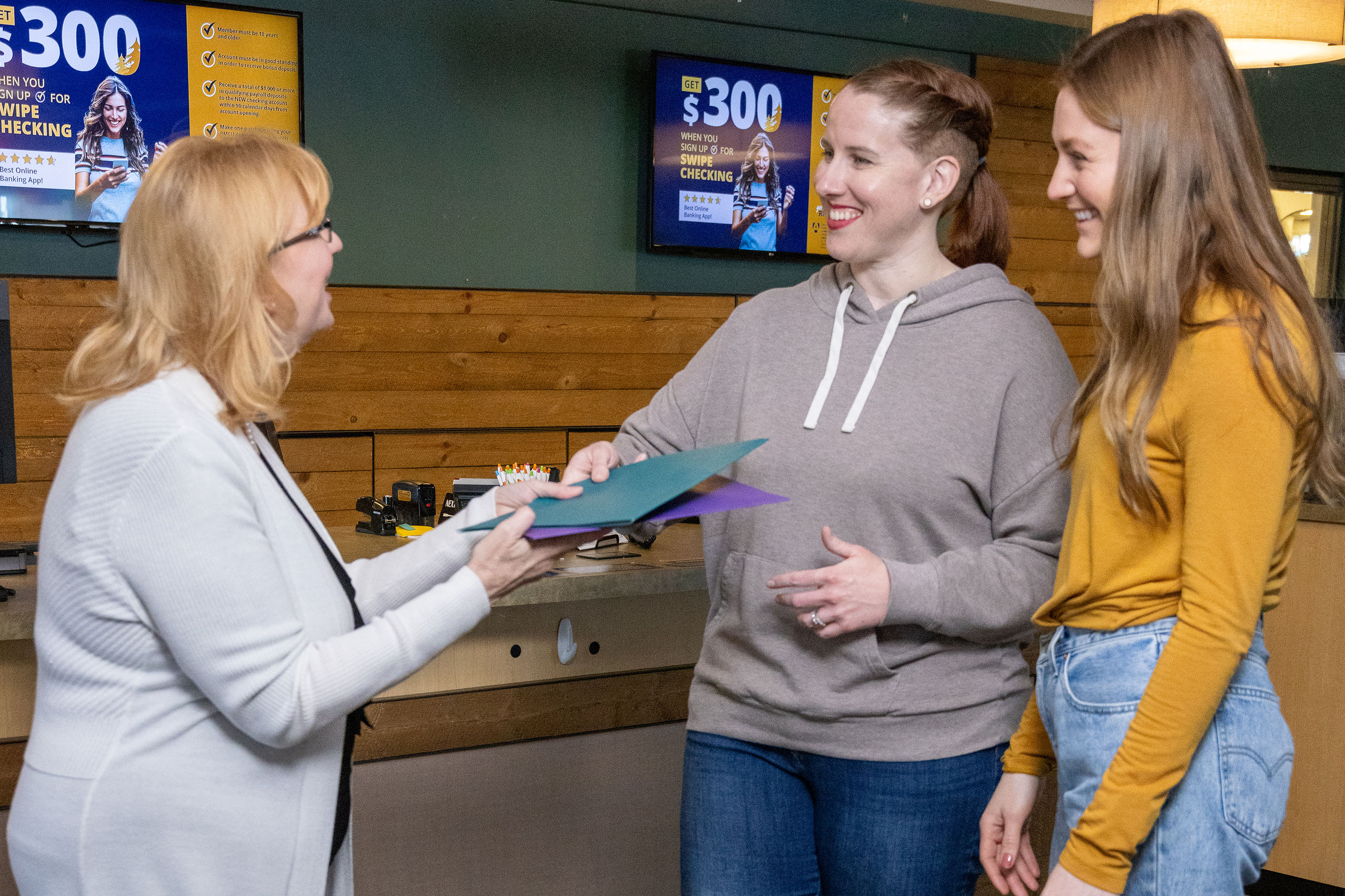 Image of two young women with a banker. 