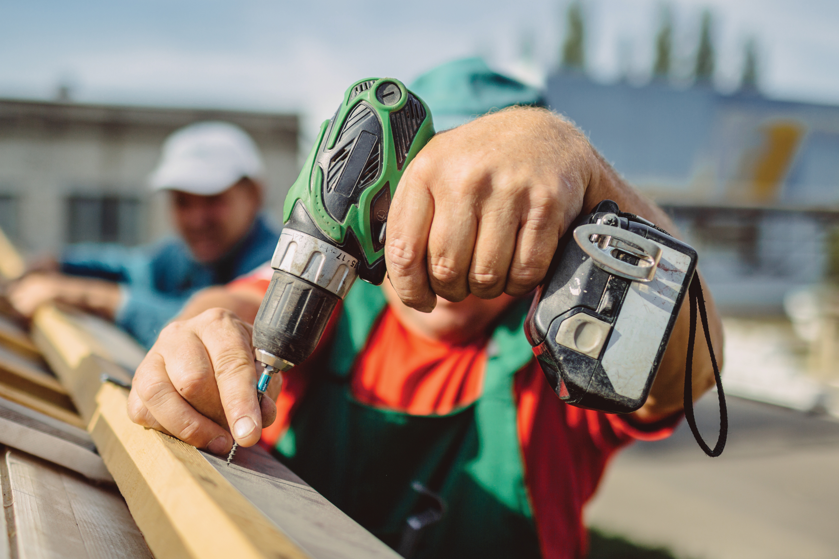 Man drilling a nail into a piece of wood