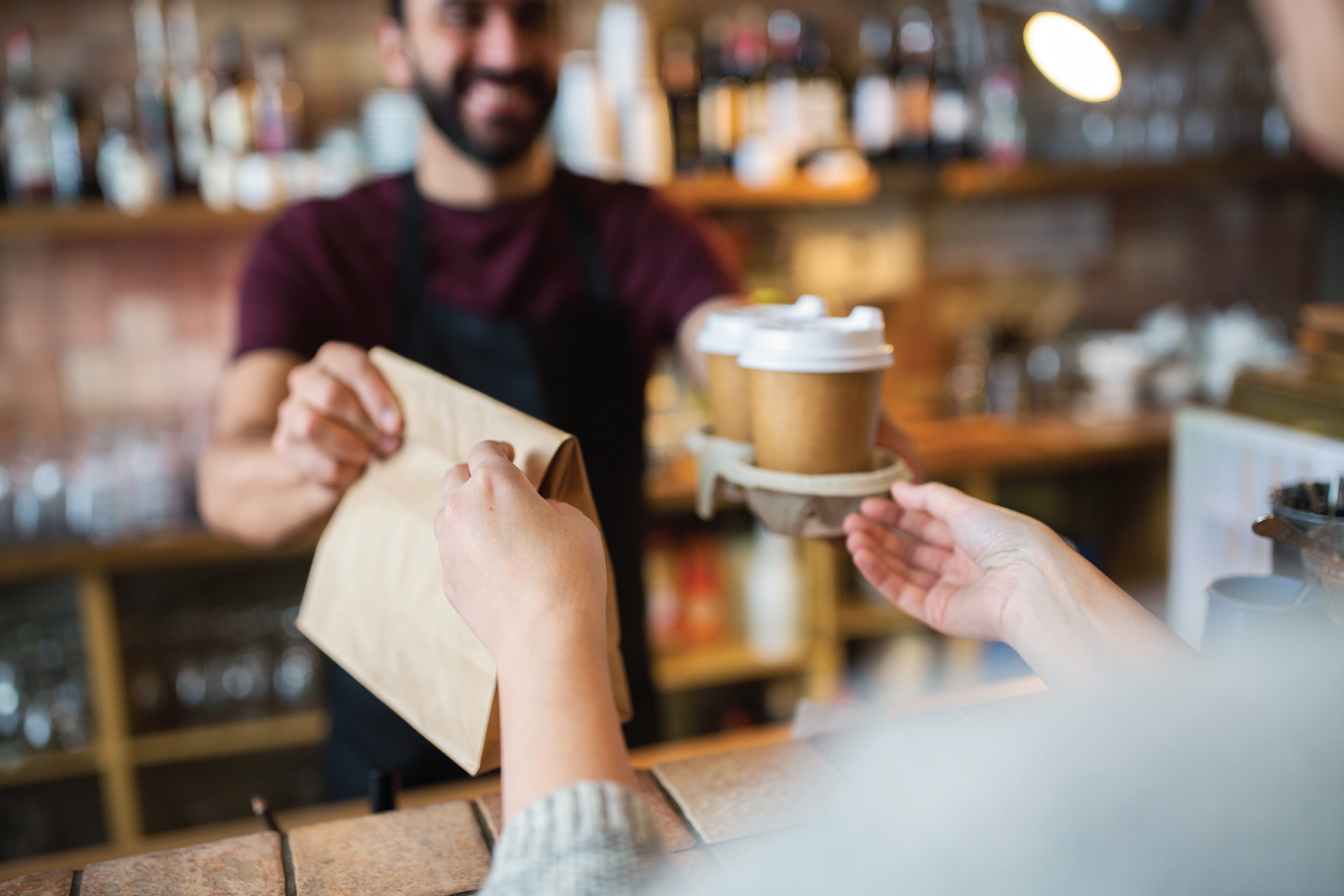 man serving coffee to a customer at a coffee shop