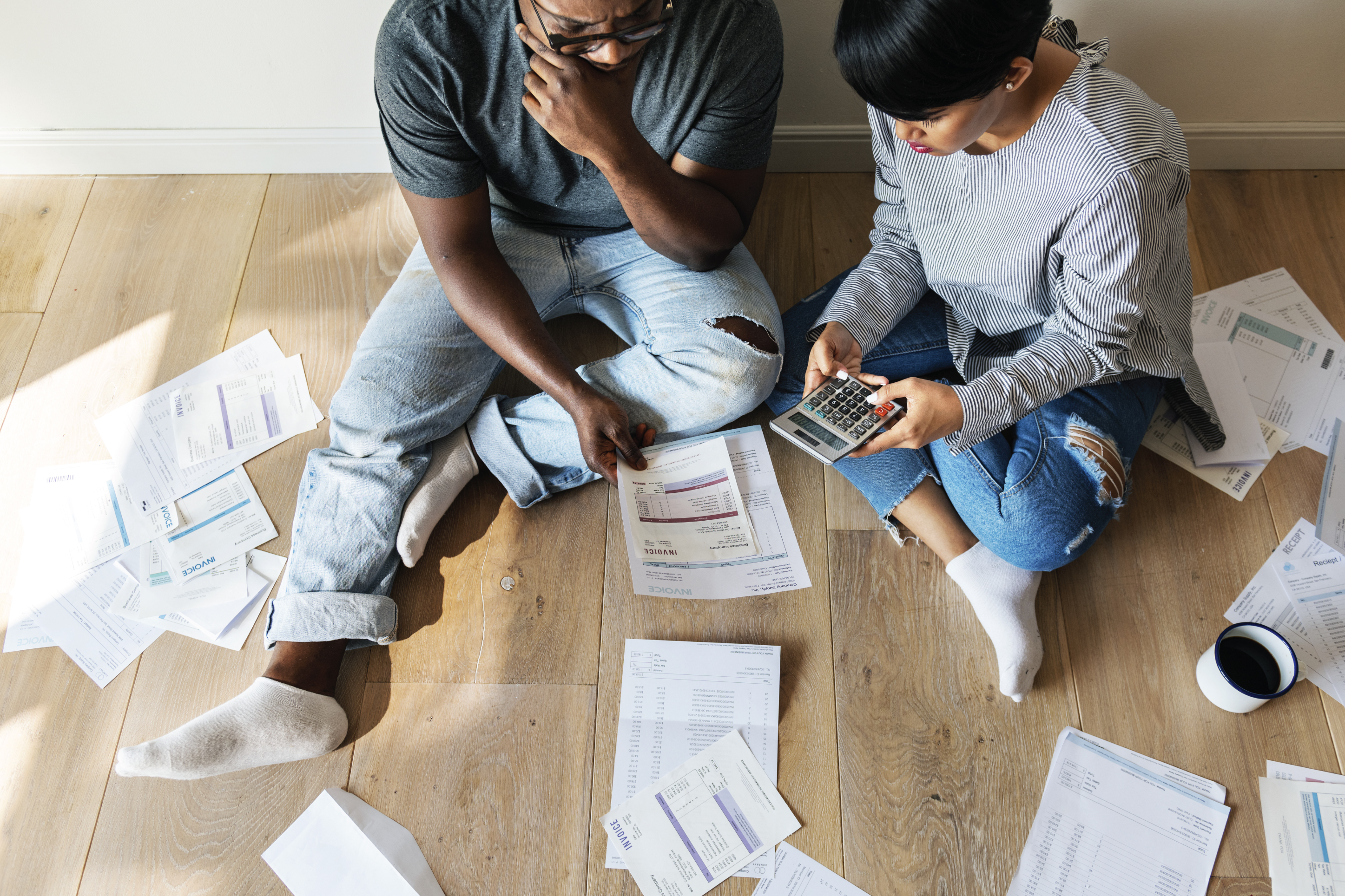 a couple looking at their bills and calculating costs