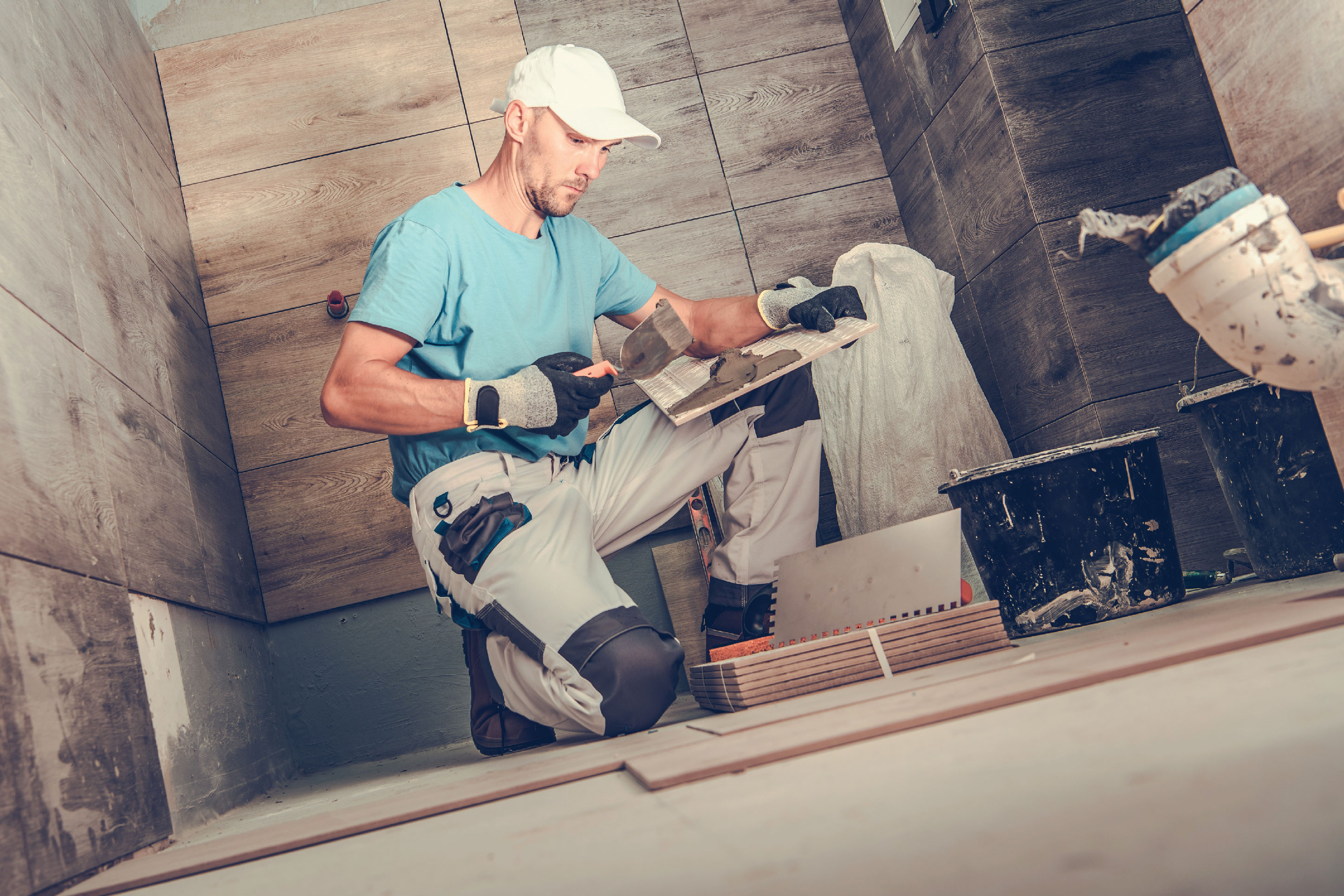 man retiling a bathroom shower