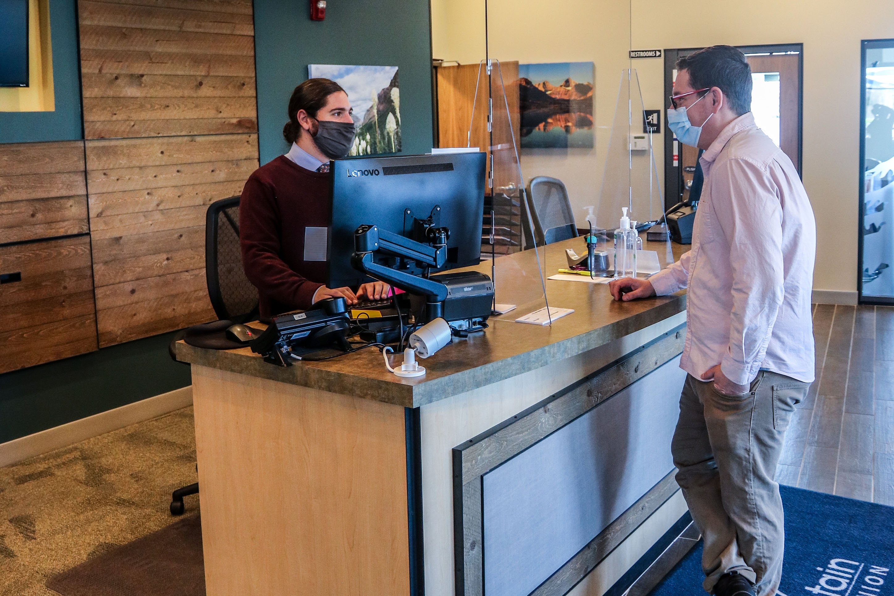 photo of a customer having an exchange with a teller at a bank